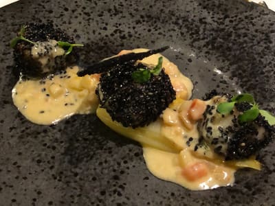 Black sesame crusted scallops on dinner plate
