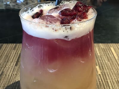 Layered cocktail with cranberries on placemat