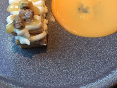 Layered cream pastry with sauce on plate
