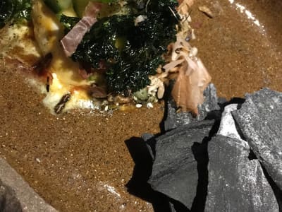 Rustic plated greens with black crisps
