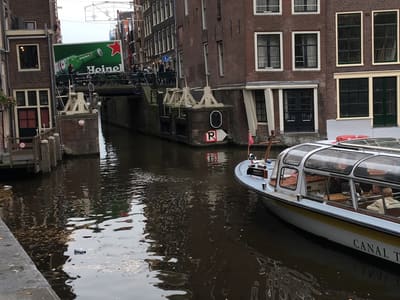 Glass-topped canal boat by historic Amsterdam houses